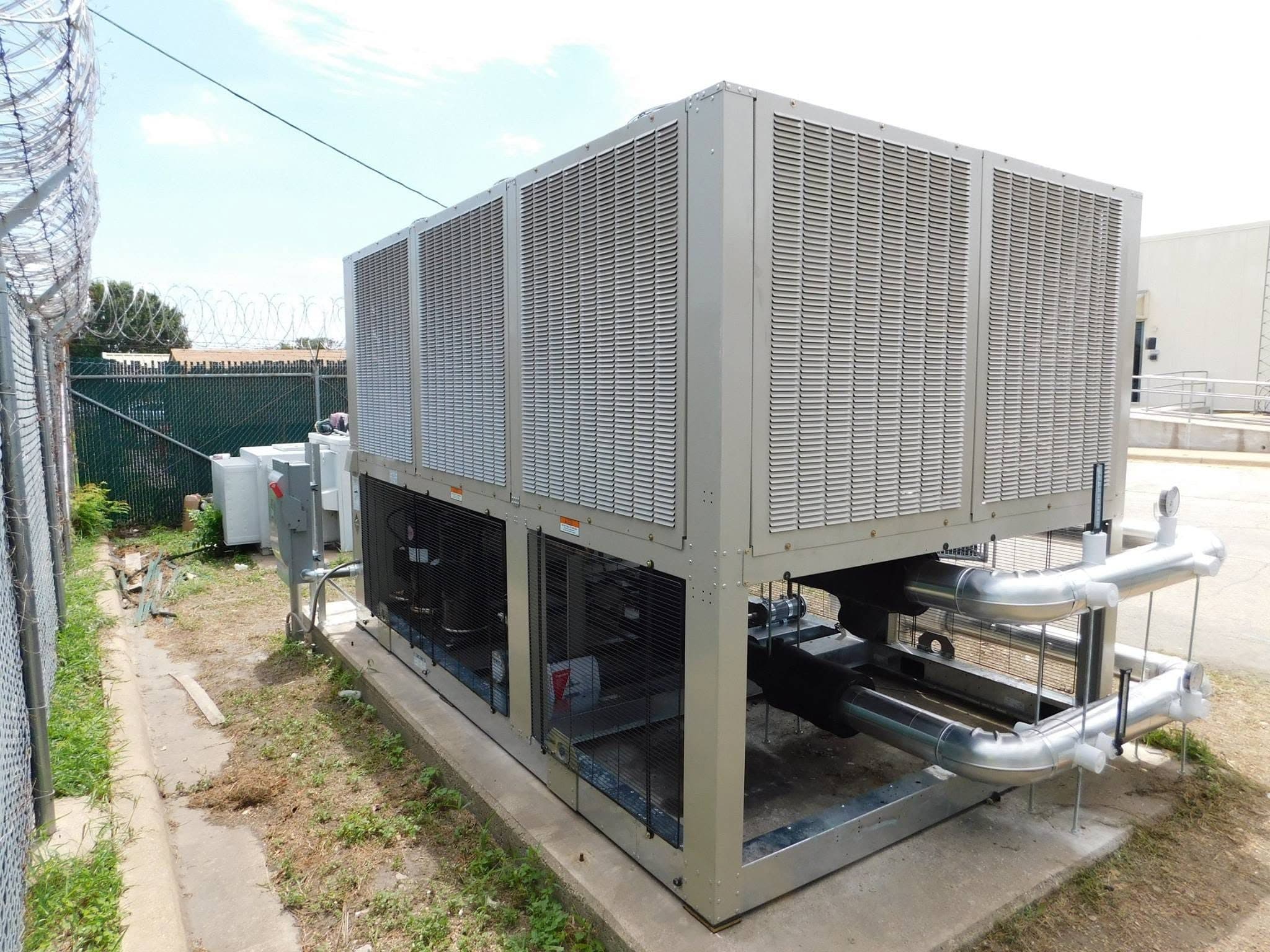 Large air-cooled chiller beside a commercial facility